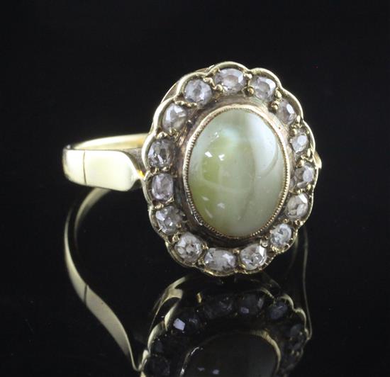 An 18ct gold, cats eye chrysoberyl and diamond oval cluster ring, size N.